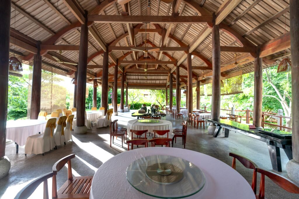 Open-air restaurant patio with tables set in a wooden archway, inviting atmosphere.