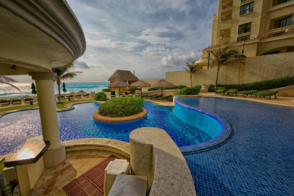 Relaxing poolside at a luxury resort in Mexico with scenic ocean views and palm trees.