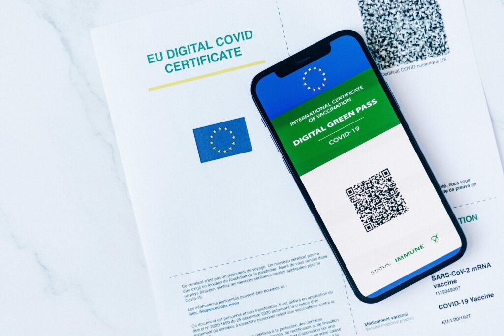 EU Digital COVID Certificate displayed on smartphone and paper form, vaccination proof.
